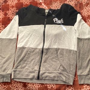 Small full zip jacket. Black white and grey striped with pink logo on hood